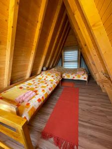 Bešenovački PrnjavorBrvnara Beli Kamen 1的阁楼卧室配有床和红色地毯