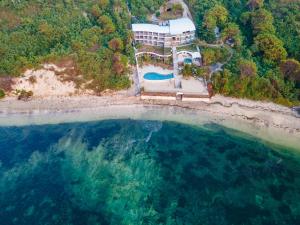 龙目岛库塔Inlight Lombok Beach Hotel的海滩上房屋的空中景致