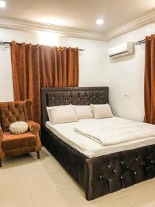 阿布贾Cozy 1 bedroom apartment in Abuja的一张床位,房间配有椅子和床筒