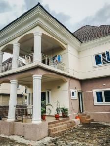 阿布贾Cozy 1 bedroom apartment in Abuja的带阳台和柱子的大型白色房屋