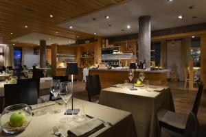 利维尼奥MOTA hotel的配有桌椅和酒杯的餐厅
