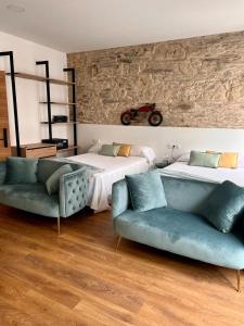 费罗尔Hostal Zahara的卧室配有两张床、一张沙发和壁挂式摩托车。