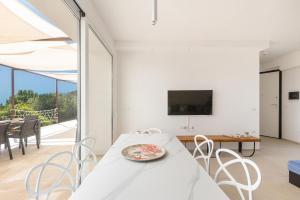 托瑞帕利Villa Briosa Maldive del Salento Pescoluse的白色的用餐室配有桌椅