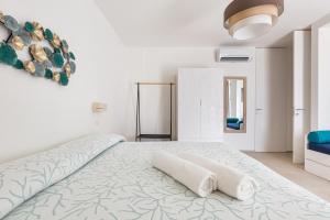 托瑞帕利Villa Briosa Maldive del Salento Pescoluse的白色卧室配有带2条毛巾的床