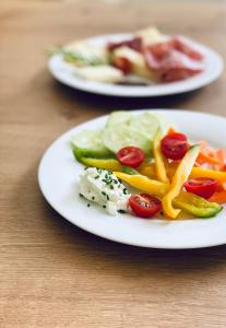 纳图尔诺Hotel Quellenhof的桌上有两盘蔬菜食品