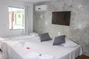 塞古罗港Porto Center Hotel的客房设有2张带白色床单的床和窗户。