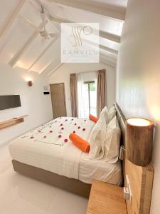 图杜RV Thoddoo Maldives - Guest House的一间卧室配有一张红色鲜花的大床
