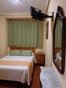 托莱多茵凡特斯旅馆的一间卧室配有一张床、镜子和电视