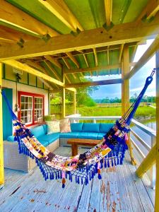 泰比岛Creekside Paradise的甲板上设有带吊床和沙发的门廊