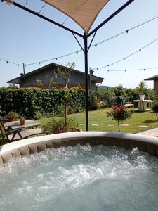 布龙泰Good Morning Etna的庭院内的热水浴池和遮阳伞