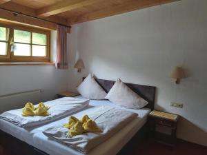 莱奥冈费恩霍夫蜜灵霍夫农家乐的一间卧室配有两张带黄色枕头的床。