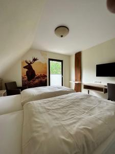 雷希Jagdhaus Rech - Ahr的卧室配有一张白色大床和一张书桌