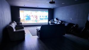 赫恩GF Studio, Secure parking, outside area, cinema(S)的客厅配有两张沙发和投影屏幕