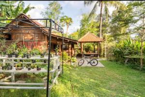 吉利阿尔Al-Shifa Healing House Lombok的一座带花园的房子和一座位于庭院的自行车