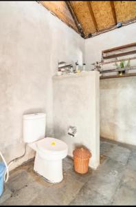 吉利阿尔Al-Shifa Healing House Lombok的一间位于客房内的白色卫生间的浴室