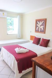 塞古罗港Porto Center Hotel的一间卧室配有两张红色和白色床单