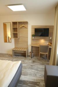 奥斯特菲尔登Kemnater Hof Apartments的客房设有书桌、电视和床。