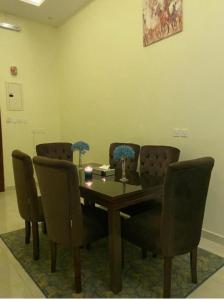 艾卜哈القصر المطار的一间带木桌和椅子的用餐室