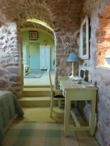 Ágios Geórgios Sykoúsis圣乔治斯考西斯传统住宅度假屋的卧室配有一张石墙桌子