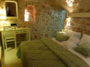Ágios Geórgios Sykoúsis圣乔治斯考西斯传统住宅度假屋的一间卧室配有一张床、一张桌子和一张书桌