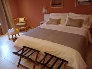 拉安戈斯图拉镇Hostería Las Semillas的卧室配有一张白色大床和一把椅子