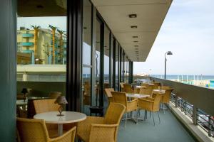 里米尼诺德伊斯特酒店的阳台餐厅,配有桌椅