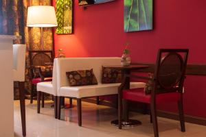 罗萨里奥1412精品酒店 的一间拥有红色墙壁和桌椅的用餐室