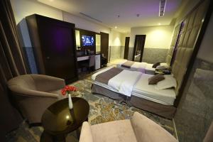 吉达Aster Hotel的酒店客房设有两张床和电视。