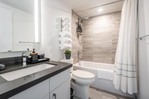 多伦多Traveller home in centre Toronto的浴室配有盥洗盆、卫生间和浴缸。