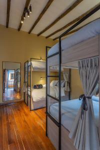 波哥大Casa Dreamer Bogotá的一间卧室配有三张双层床和镜子