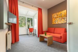 科赫姆科赫姆公园酒店 的客厅配有红色的沙发和桌子