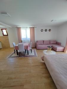 兹拉蒂博尔Apartments Marjanović的客厅配有粉红色的沙发和桌子