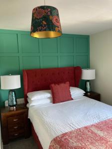 利斯本Overdale Motel的一间卧室配有一张带红色床头板的床和两盏灯。