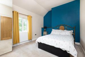 StanleyCanal Side Cottage Wakefield的一间卧室设有蓝色墙和一张床