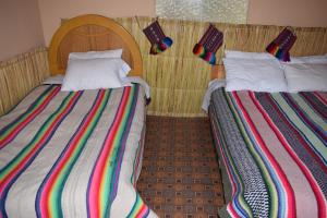 HuillanopampaTaquile Sumaq Wasi - Casa de Felipe e Ines的两张睡床彼此相邻,位于一个房间里