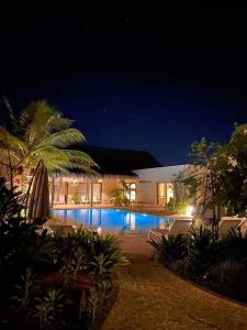 恩加帕鲁La Maison Vanille的一座晚上设有游泳池的房子