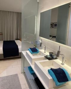 滨海帕尔姆Casa Las Olas的浴室设有2个水槽、1张床和1面镜子