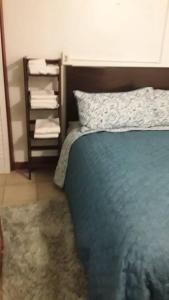 拿撒勒Catherine's Retreat的一间卧室配有蓝色的床和带毛巾的架子。