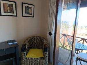 爱德华港Ocean View Villas F16 Port Edward的房间里的柳条椅和黄色枕头