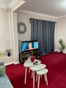 鲁特姆Luxurious and Elegant Homestay in Kent的客厅配有桌子和电视