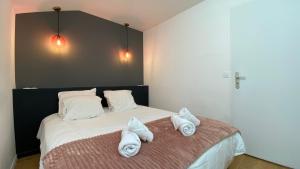 巴斯洛内特La Capitale - Les Gîtes de L Argile的一间卧室配有带毛巾的床