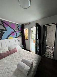 伊基克hotel velero cavancha的卧室配有一张大床,墙上挂有绘画作品