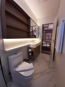 伊塔佩马I Am Design Hotel Itapema by Hotelaria Brasil的一间带卫生间、水槽和镜子的浴室