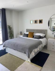 直布罗陀Ardwyn Studio Apartments Gibraltar的一间卧室配有一张大床、枕头和镜子