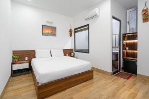 岘港Nguyên Hương Hotel的卧室配有白色的床和窗户。