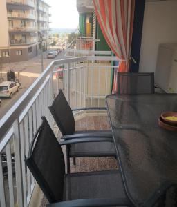 皮内达德马尔Apartament LA SAL的阳台配有桌椅和街道。