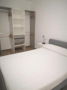 皮内达德马尔Apartament LA SAL的卧室配有白色的大床和架子