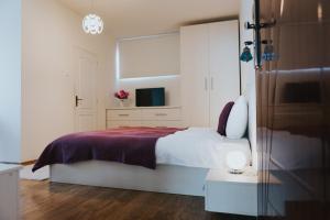 巴亚马雷Camelia's cozy place的一间白色卧室,配有床和电视