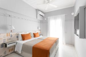帕罗奇亚阿格诺塔酒店的白色卧室配有带橙色枕头的大床