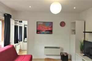 Cherry HintonModern Spacious Detached Cottage in Cambridge的客厅配有红色沙发和电视